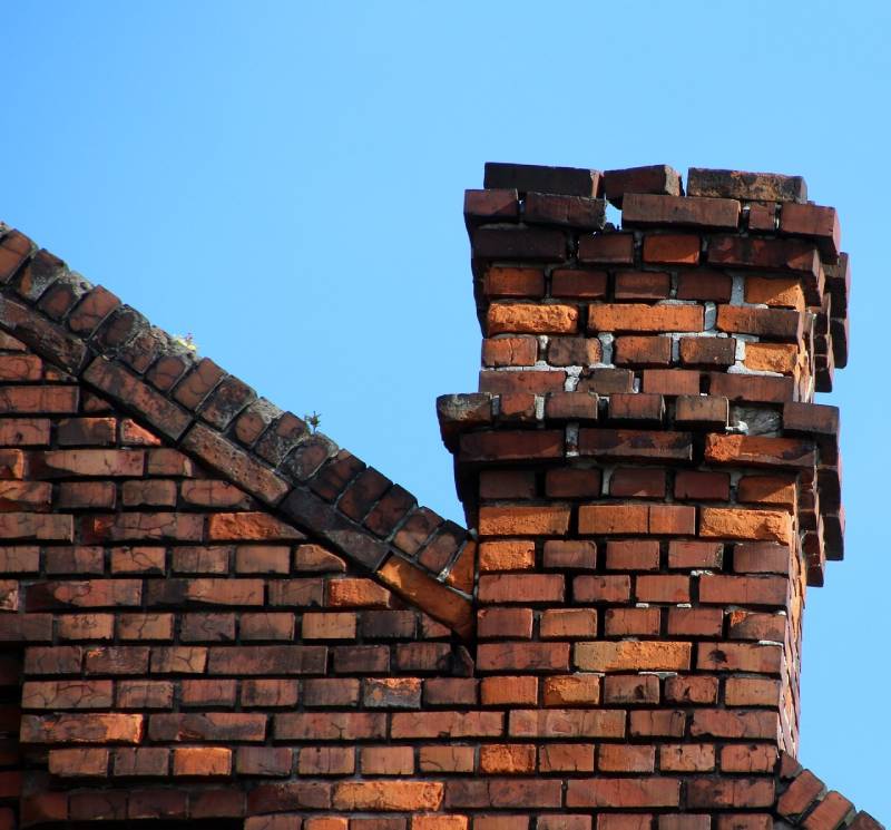 Damaged chimney on an Acton home showing cracks and missing mortar